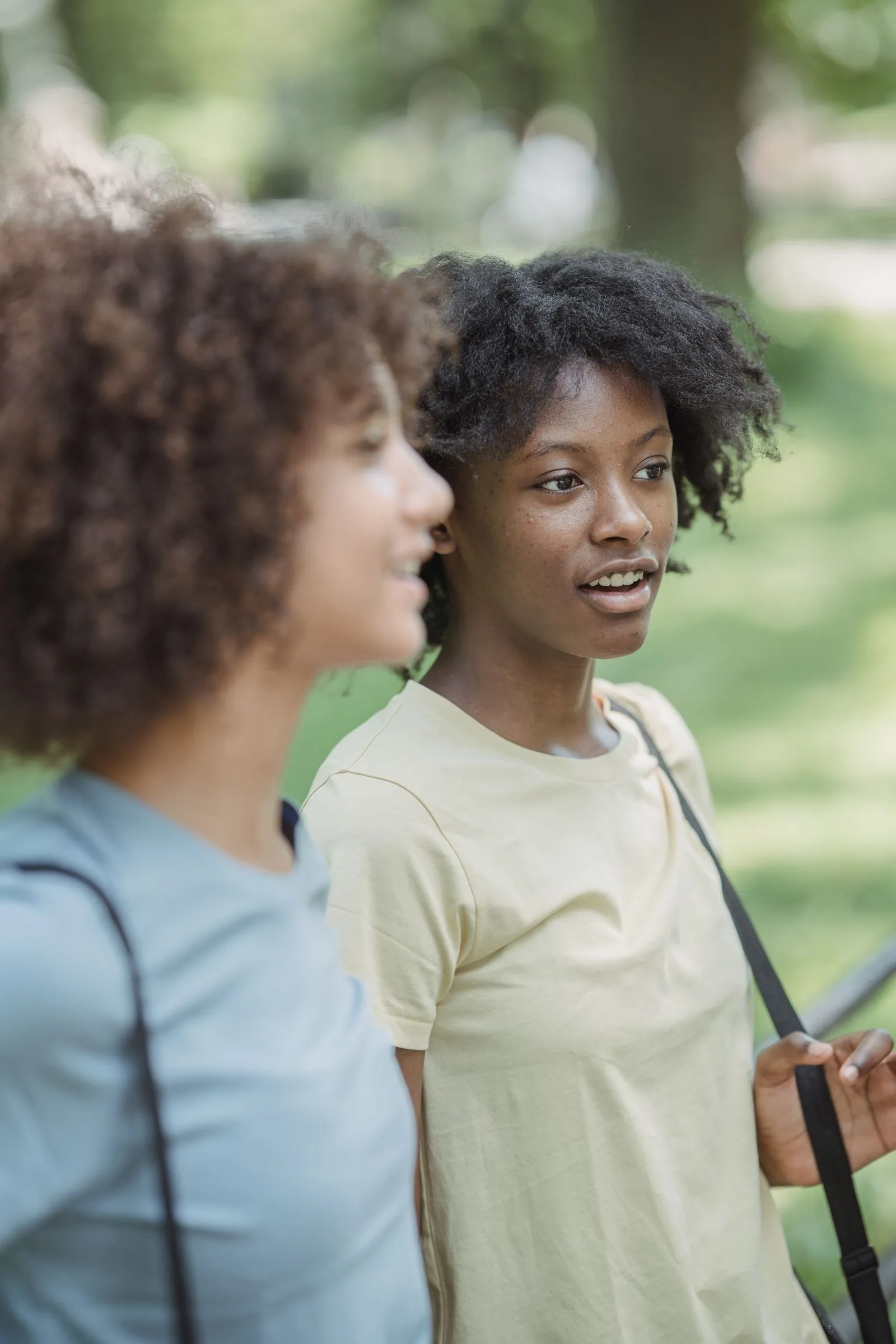 Two teenage friends talking while walking outdoors